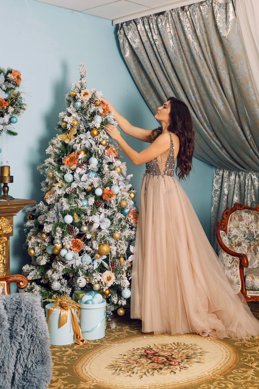 woman arranging white christmas tree